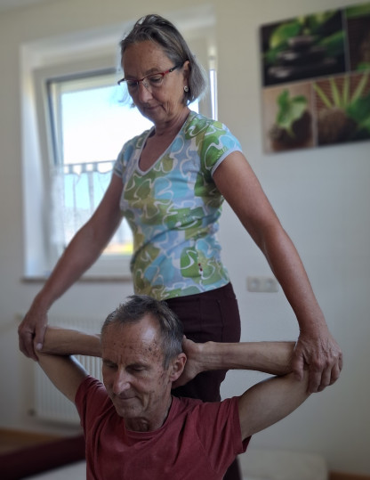 Close-up hands applying shiatsu pressure on shoulders, serene spa ambience